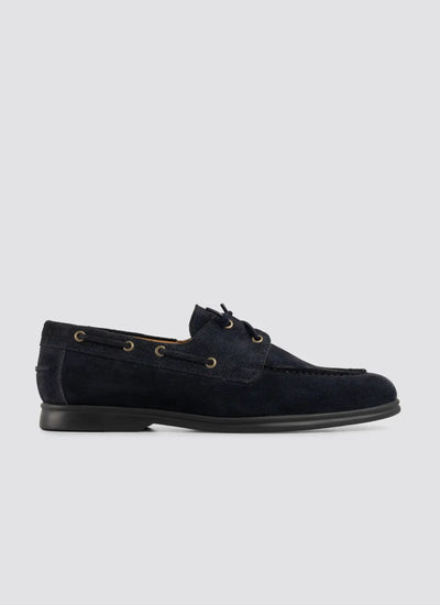 Men's navy blue suede boat shoe with lace-up detail and rubber sole on a plain background 