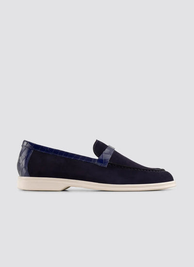 Navy blue loafer shoe on a light gray background 