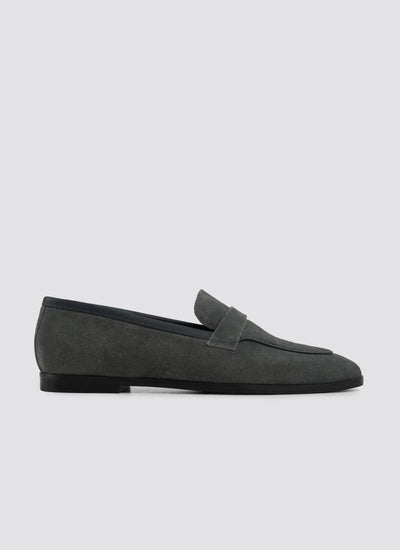 Black patent leather loafer with gold buckle on a white background 