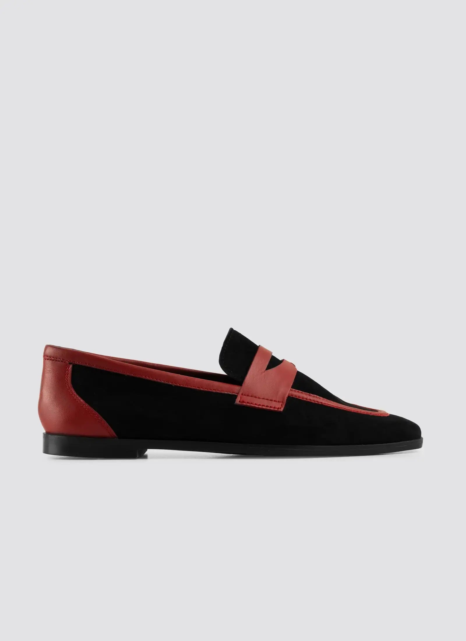Black and red loafer shoes on a light gray background #color_black