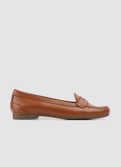 White sneaker with brown sole on a light beige background 