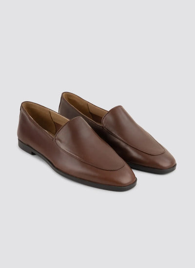 Pair of brown leather loafers on a light gray background  