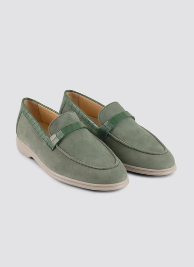Pair of green loafers on a light gray background 
