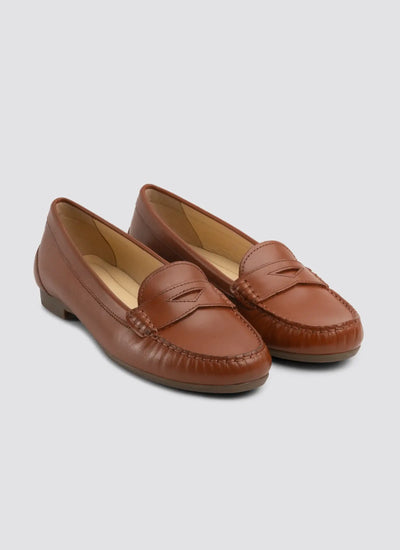 Pair of brown loafers on a light gray background  