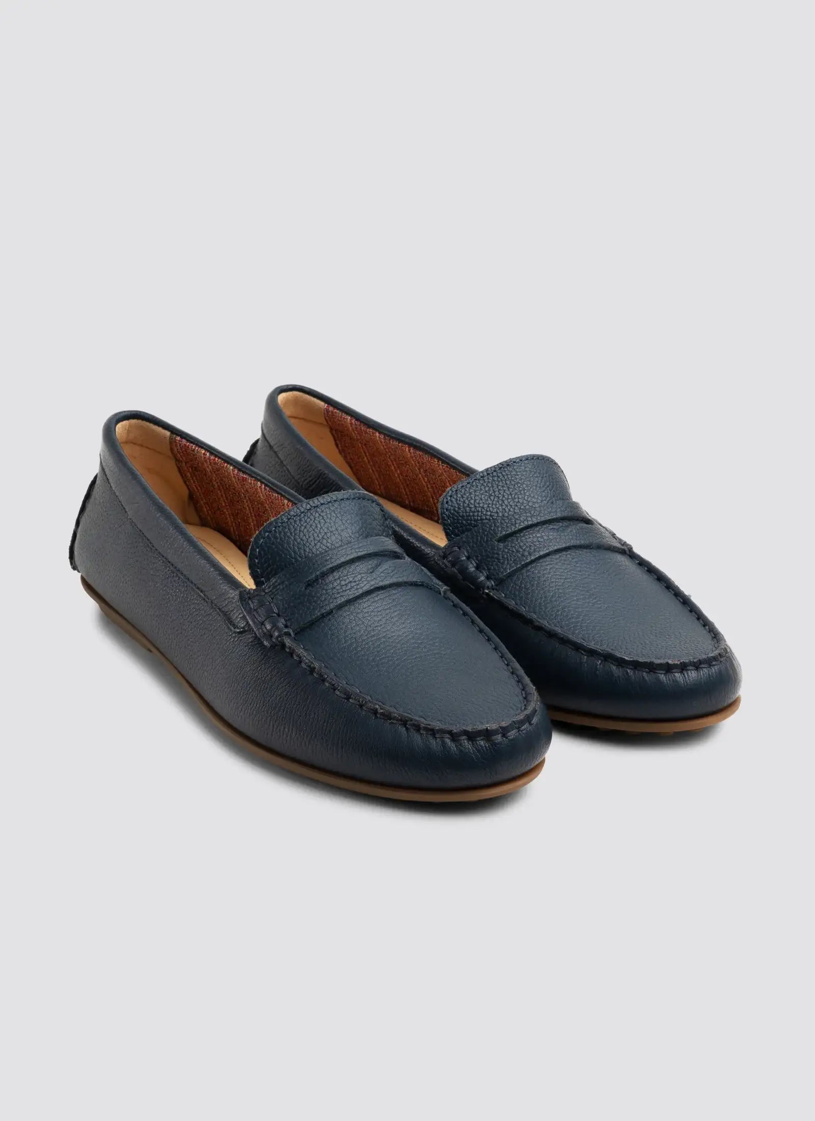 Pair of blue loafers on a light gray background  