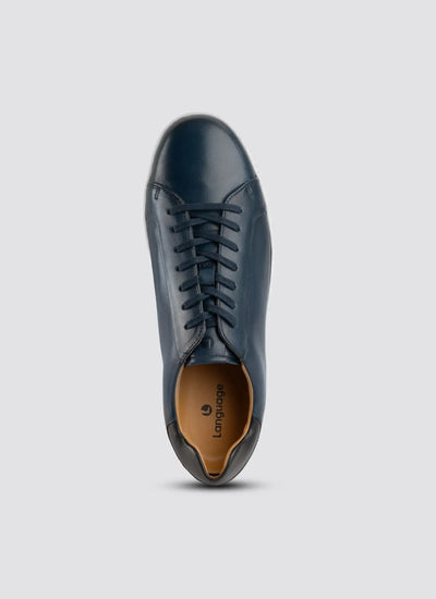 Navy blue leather shoe on a light gray background 