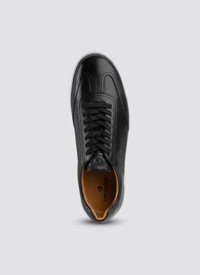 Top view of black leather sneaker with black laces and tan inner lining 