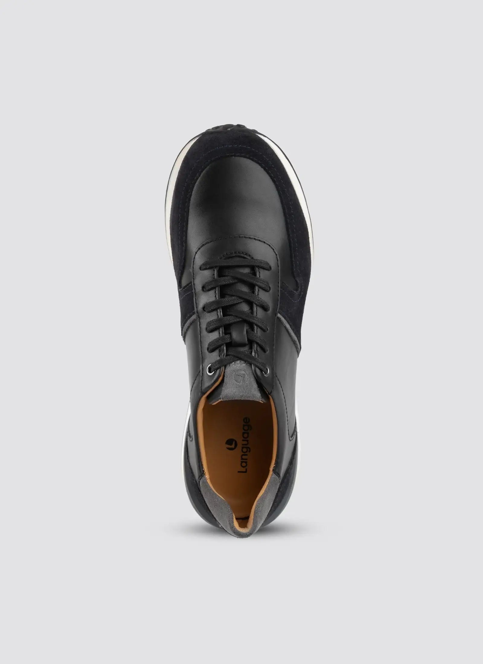 Top view of black leather and suede sneaker with laces on a plain background 
