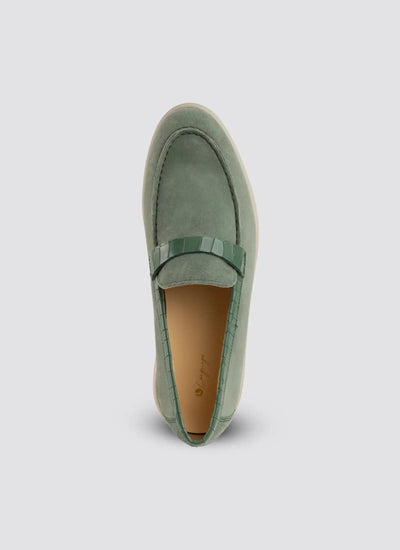 Green loafer shoe on a light gray background 
